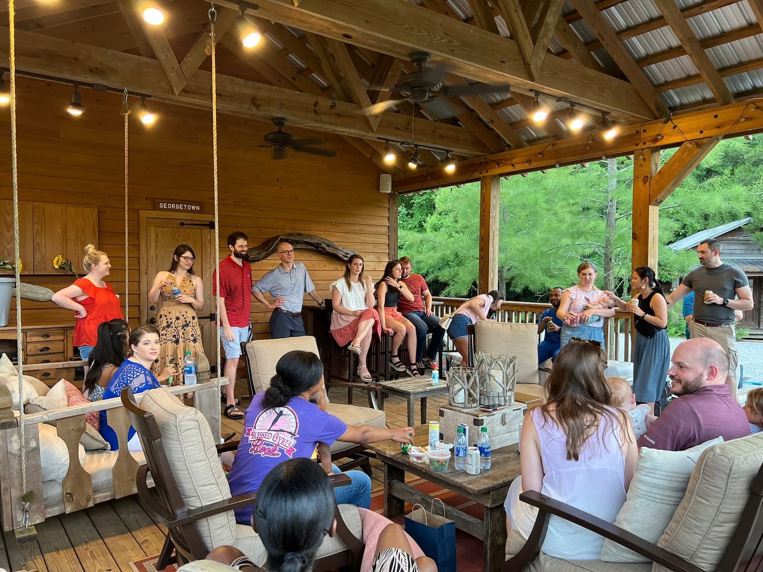Med-Peds students at an outdoor party on a porch with rustic decor.